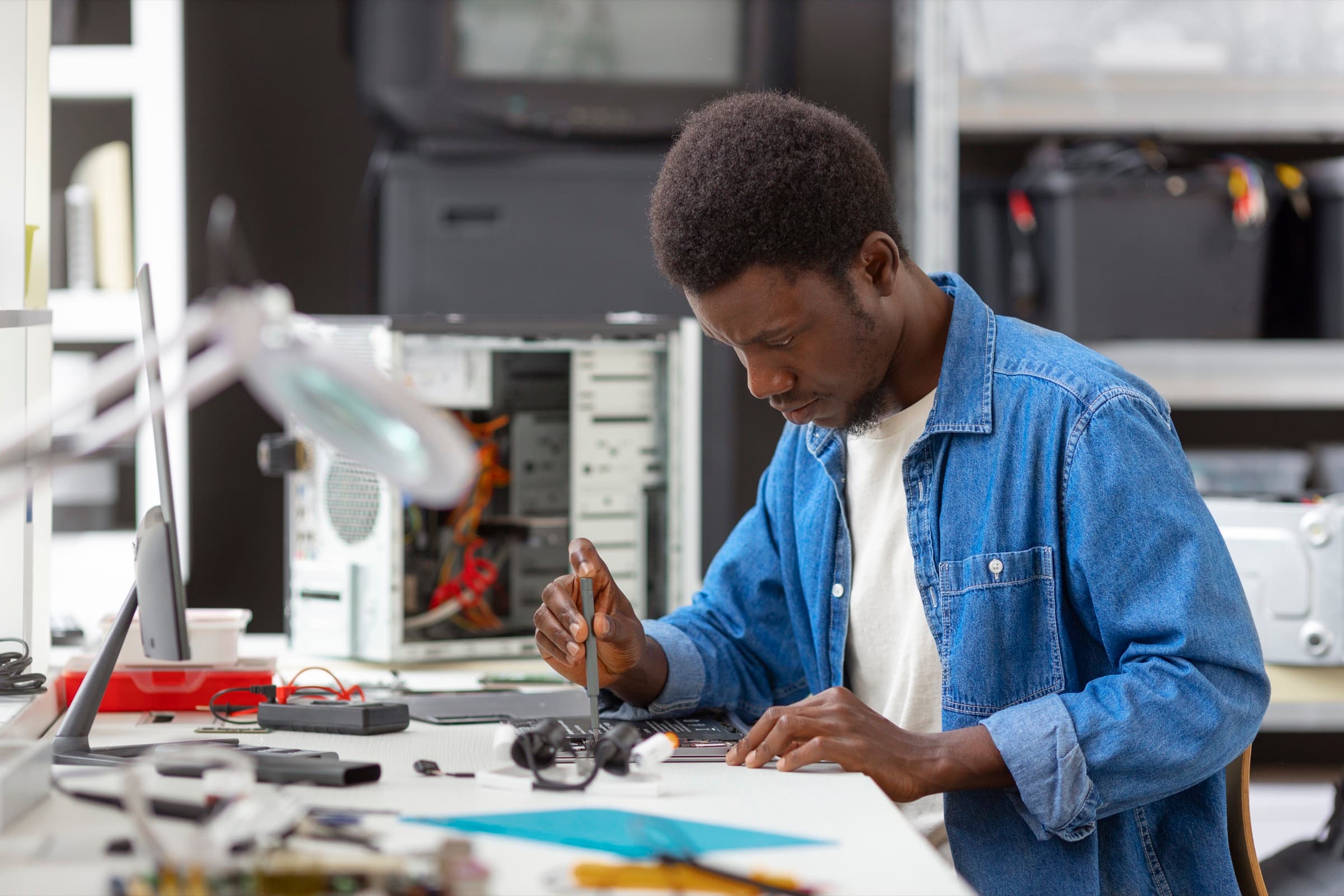 Technician carefully repairing a device at the Gadgets Tanzania workshop